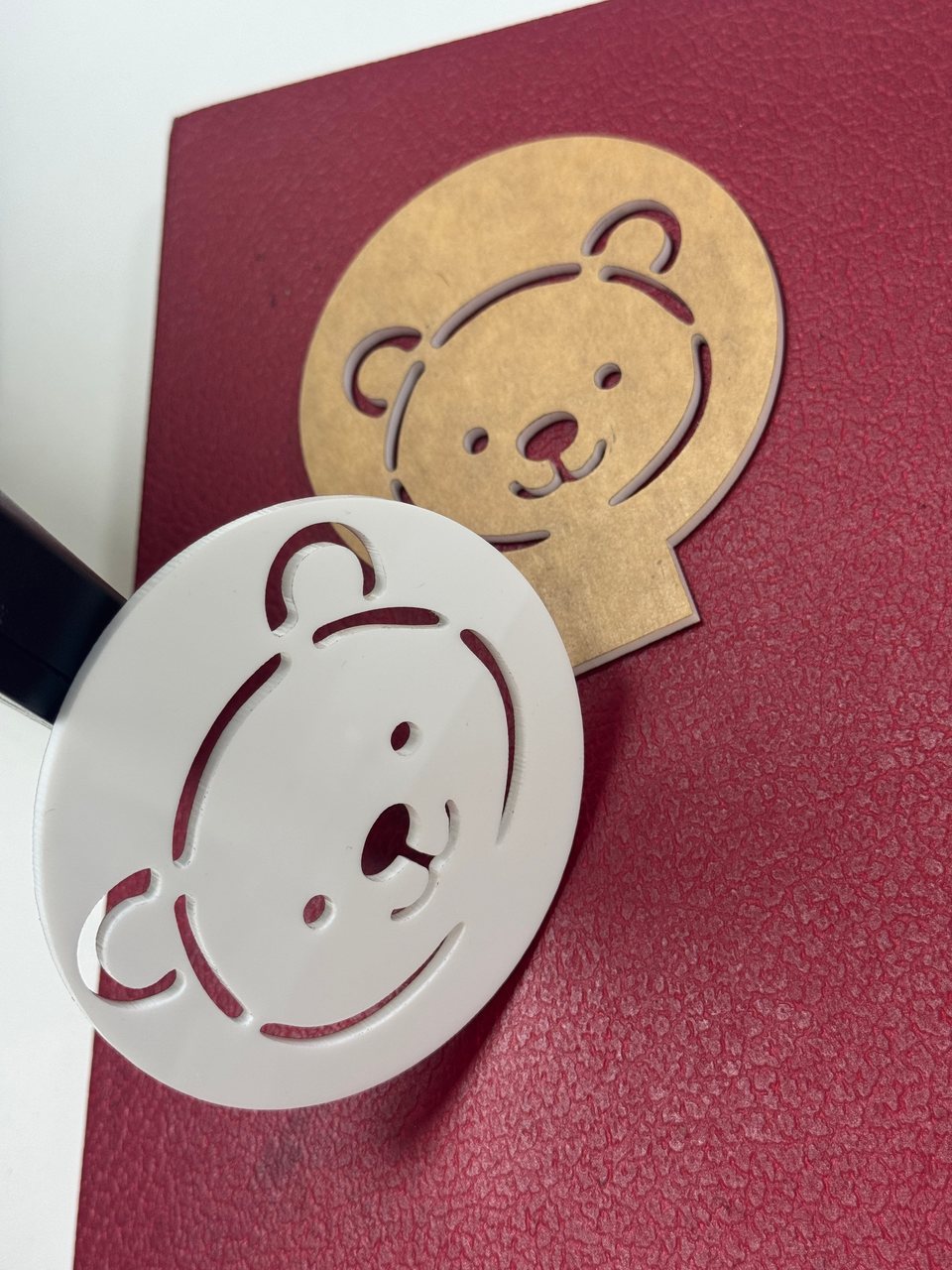 White and gold-coloured cut-out shapes with a bear motif.