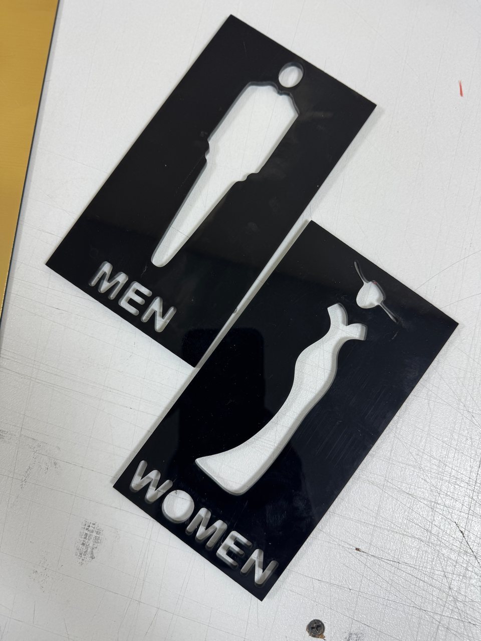 Cut-out restroom symbols and lettering on black panels.